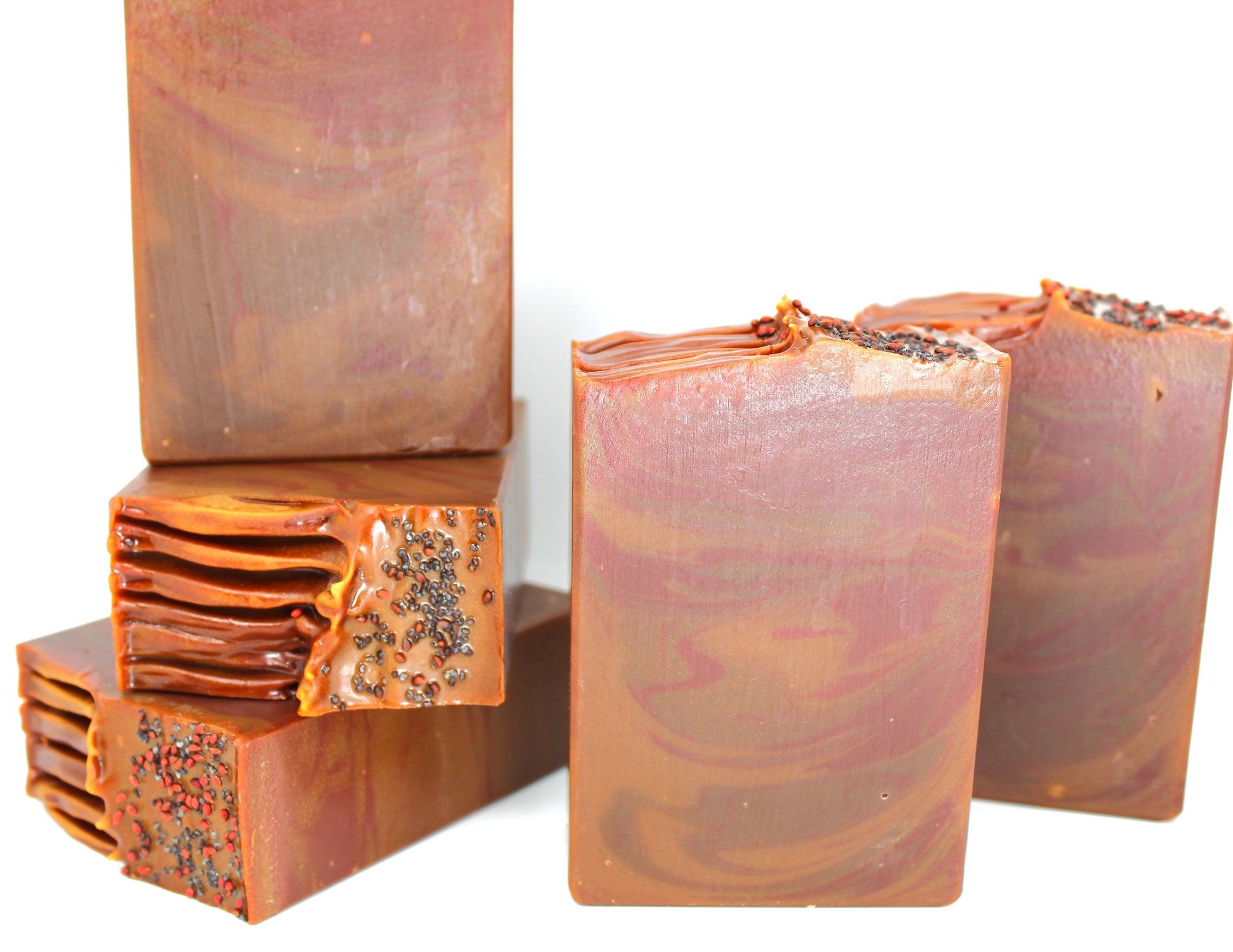 Brown and red swirled soap stacked on a white background.
