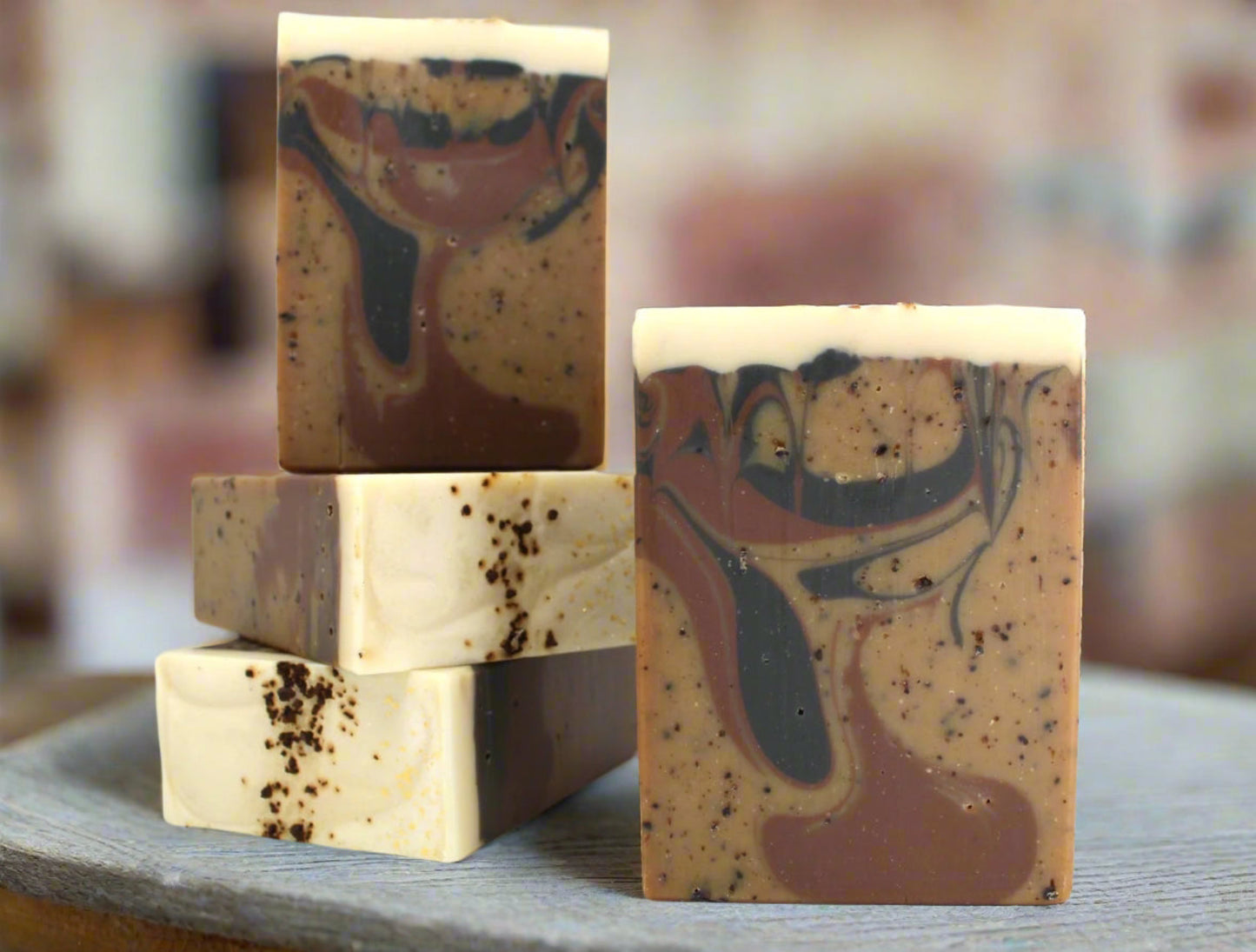 Multiple bars of brown soap with coffee grounds and swirls on a white background.