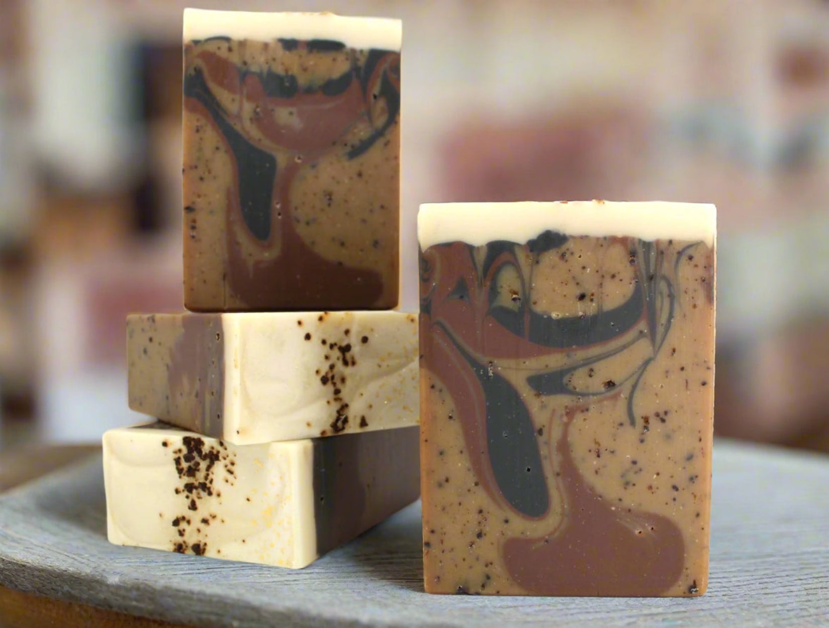 Multiple bars of brown soap with coffee grounds and swirls on a white background.