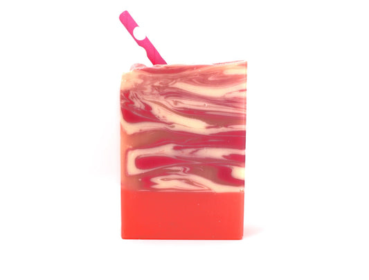 Pink, White, and Orange bar soap with swirls and a pink paper straw on a white background.