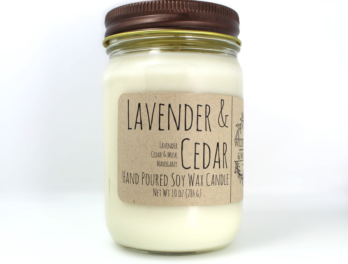 White wax candle in a mason jar with a rustic brown metal lid. Kraft brown label with black text. White background.