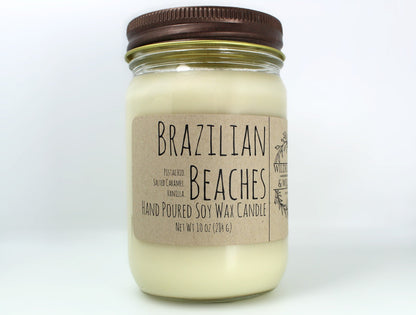 White wax candle in a mason jar with a rustic brown metal lid. Kraft brown label with black text. White background.