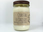 White wax candle in a mason jar with a rustic brown metal lid. Kraft brown label with black text. White background.