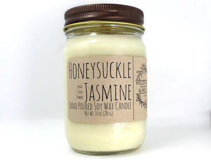 White wax candle in a mason jar with a rustic brown metal lid. Kraft brown label with black text. White background.